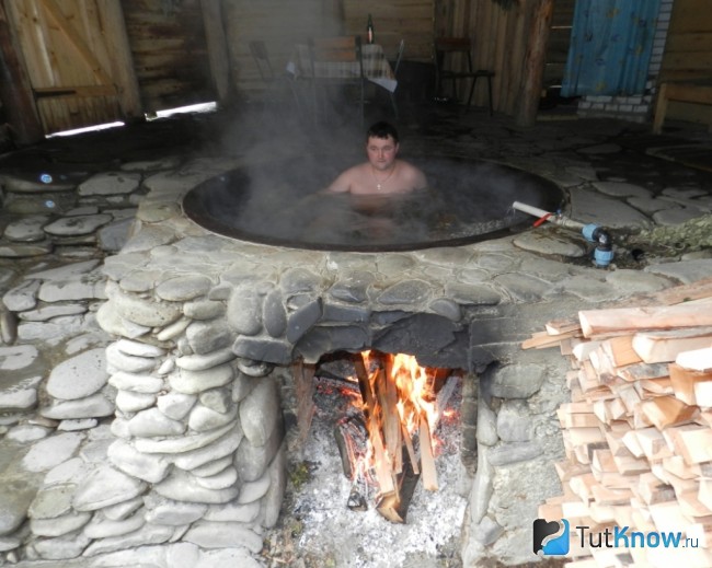 Подогрев воды в чугунном чане на костре