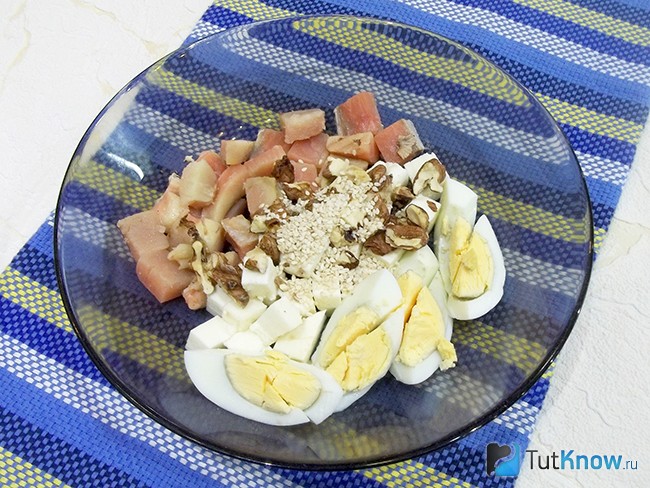 В тарелку к продуктам салата добавлены семена кунжута