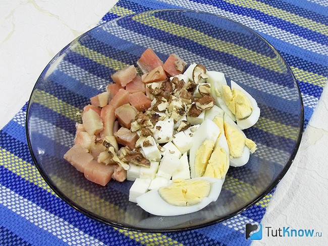Грецкие орехи очищены, подробленны и добавлены в тарелку к продуктам салата