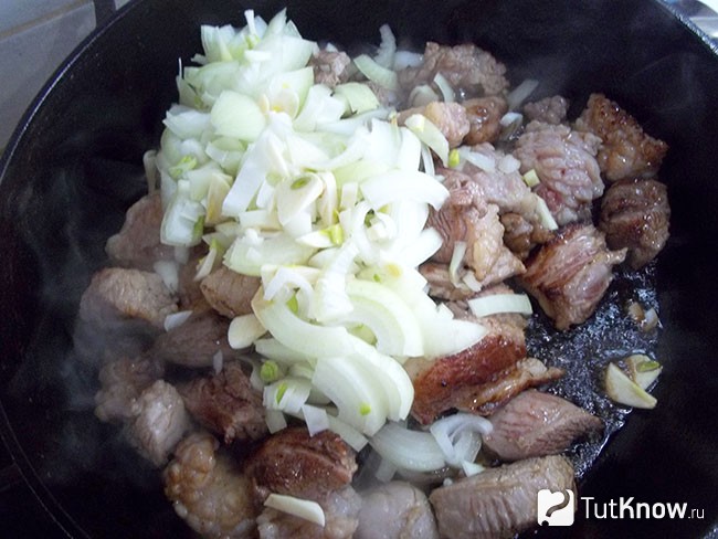 Репчатый лук и чеснок добавлены жариться в сковороду к мясу
