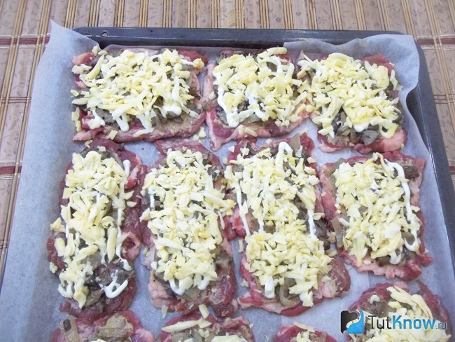 Мясо присыпано тертым сыром