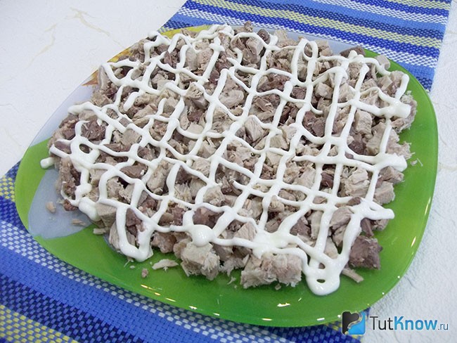 Отварное мясо нарезано кубиками, выложено на блюдо и полито майонезом
