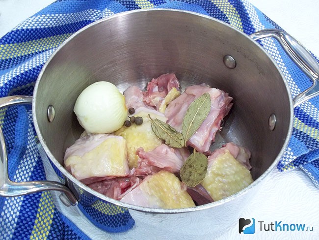 Нарезанное мясо и очищенный лук опущены в кастрюлю для варки бульона