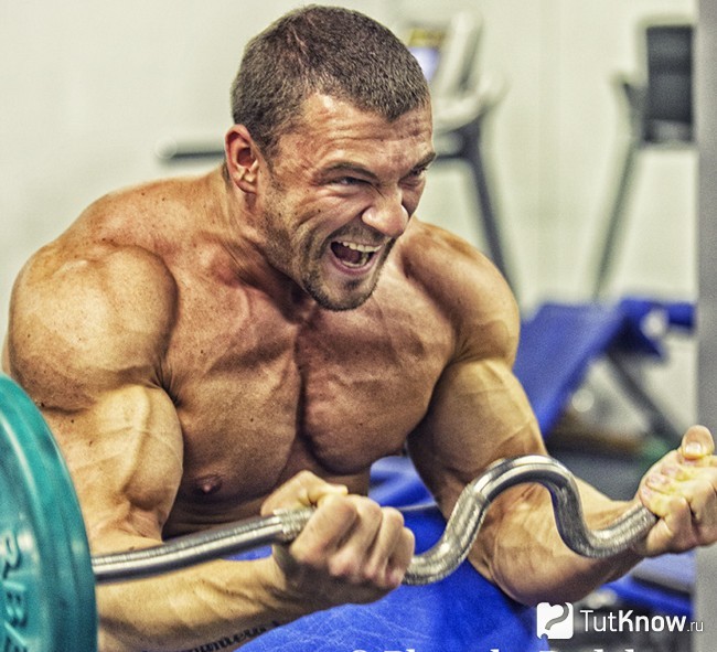 Спортсмен тренируется со штангой