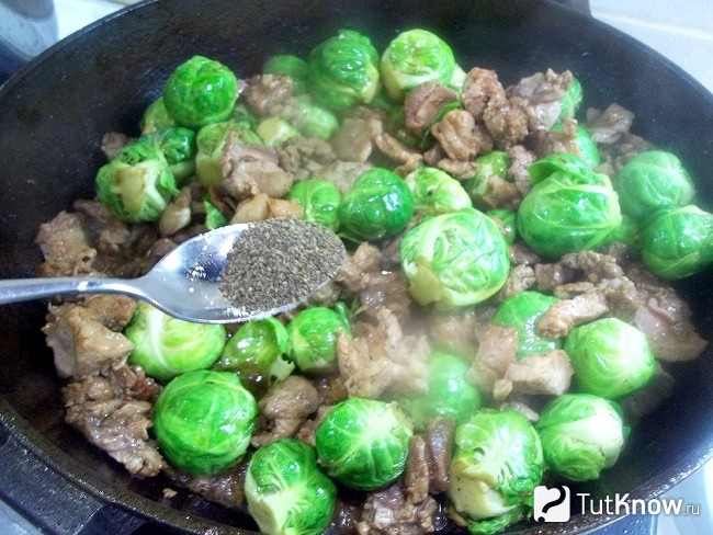 Мясо жарится в сковороде с капустой