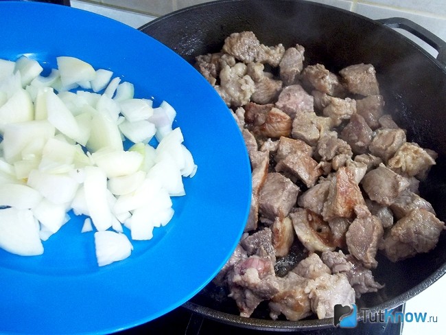 Мясо с луком жарится в сковороде