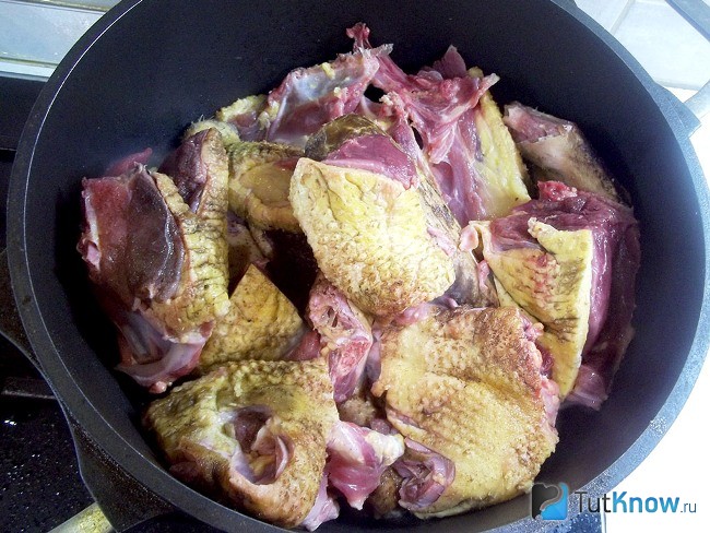 Нарезанная утка кусочками жарится в сковороде