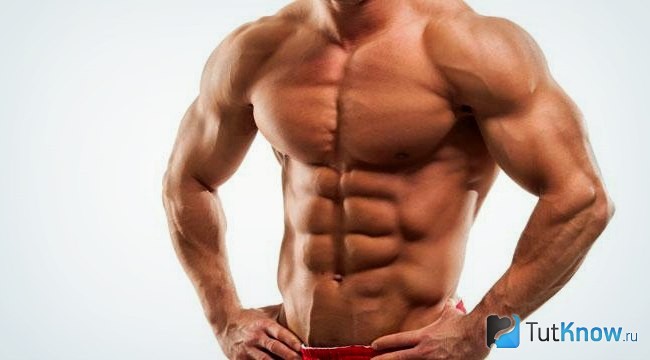 Спортсмен демонстрирует рельефные мышцы пресса