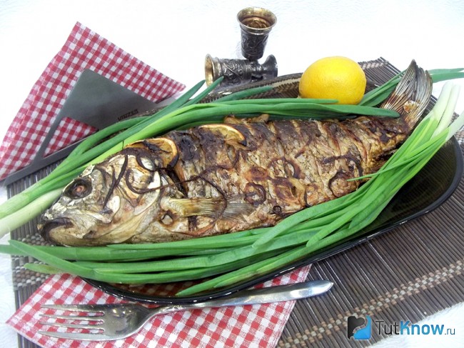 Готовый запеченный карп с луком и лимоном
