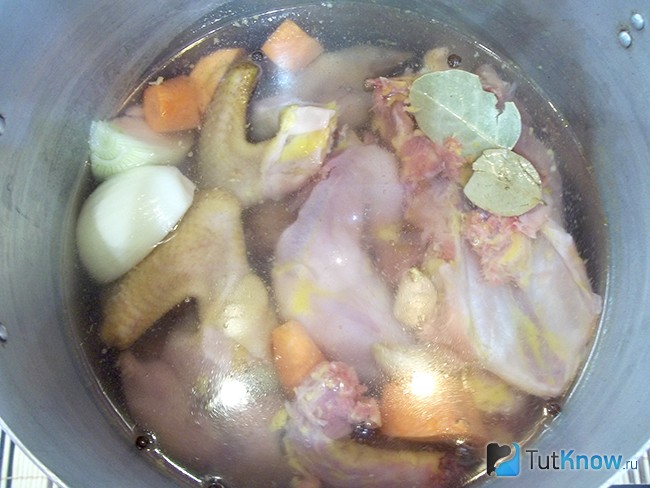Свиные ножки, курица и овощи опущены в кастрюлю