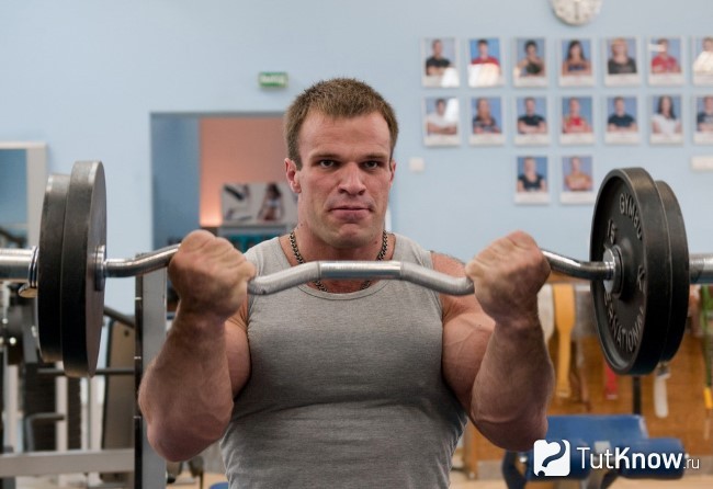 Спортсмен выполняет жим штанги сидя