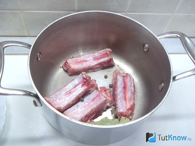 Ребра нарезаны кусочками и опущены в варочную кастрюлю
