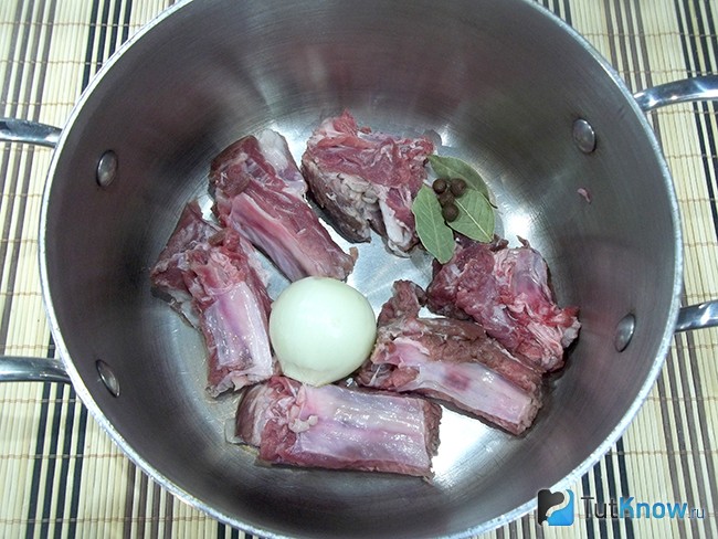 Мясо, лук и пряности опущены в кастрюлю