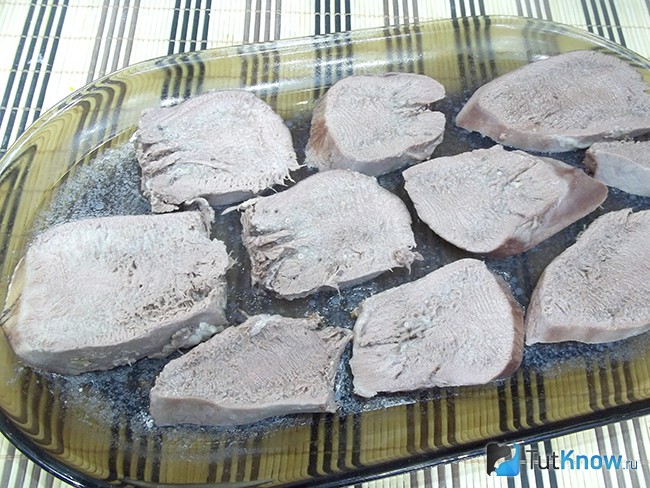 На застывший бульон выложены кусочки языка
