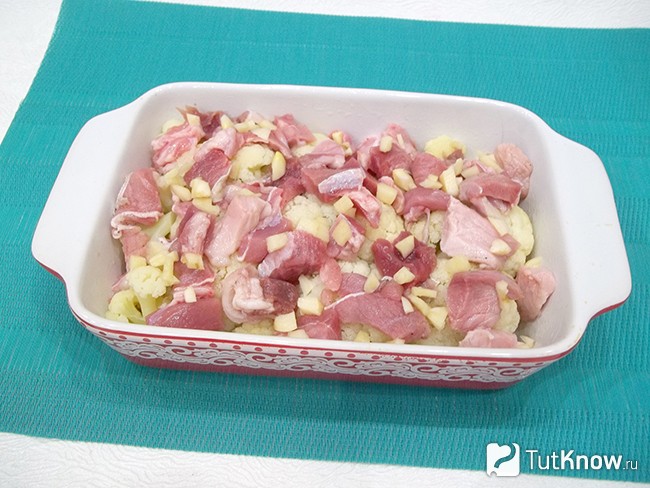 Мясо и чеснок выложены в форму к капусте