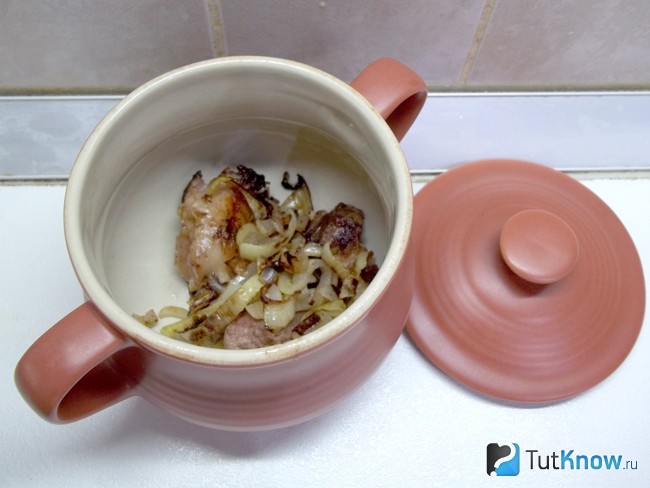 Мясо с луком погружено в горшочки