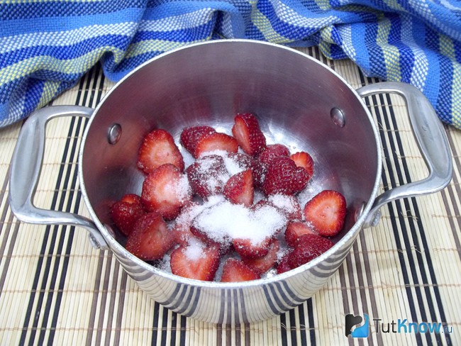 Клубника помещена в кастрюлю и засыпана сахаром