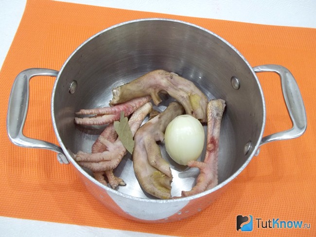 Куриные лапки опущены в кастрюлю
