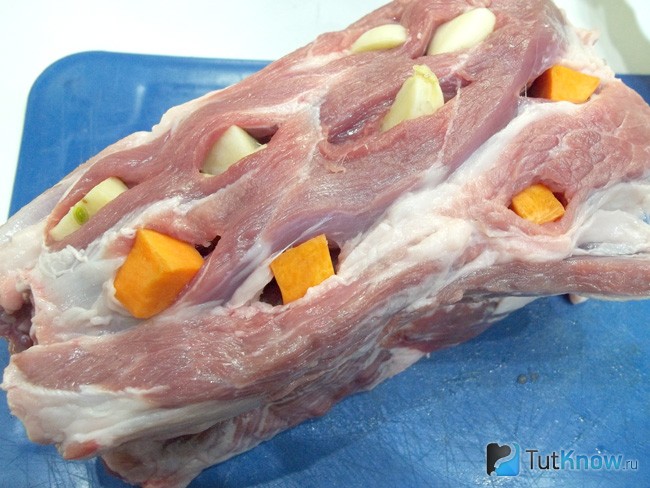 Мясо нафаршировано чесноком и морковью