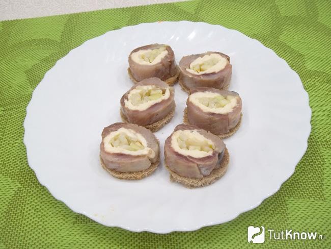 На хлеб выложена селедочная закуска