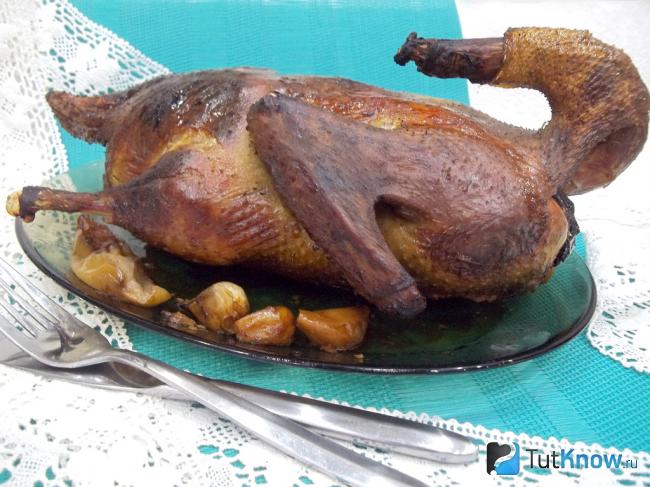 Готовая утка, фаршированная яблоками в медовом соусе
