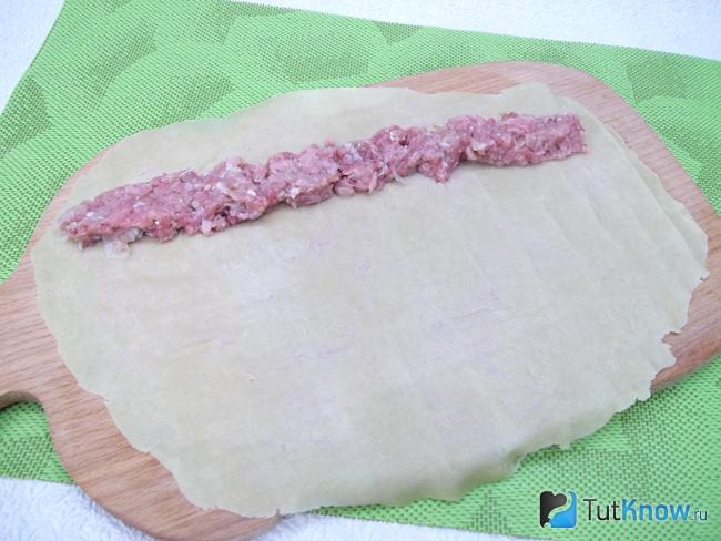 На раскатаное тесто выложен фарш