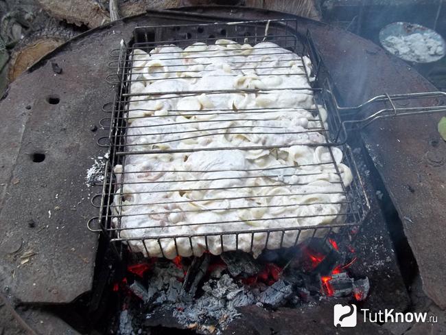 Мясо жарится на мангале
