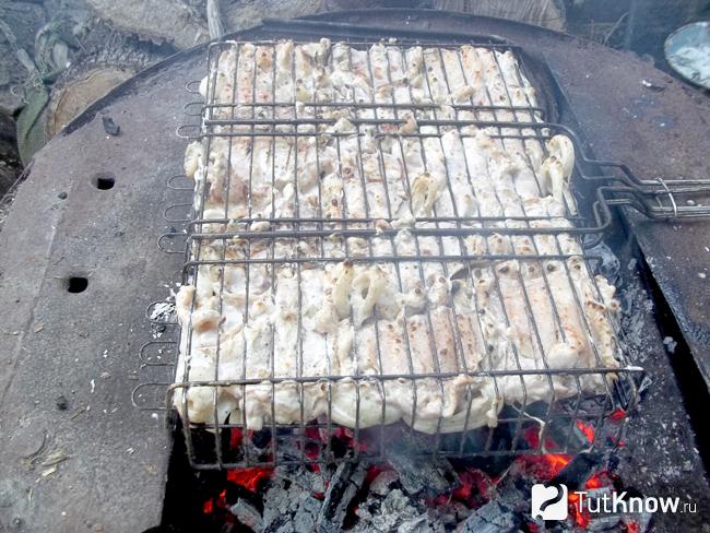 Мясо жарится на мангале