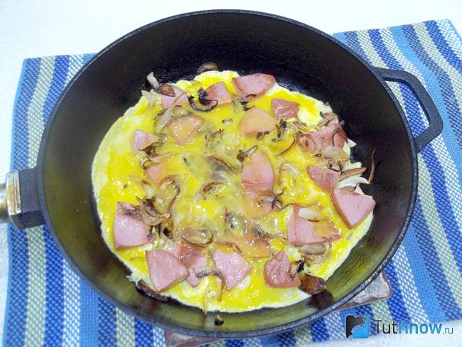 Лук с колбасой залиты яйцами