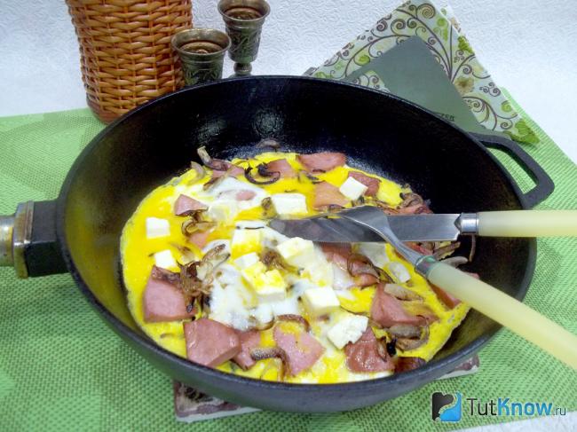 Готовый омлет с колбасой, луком и сыром