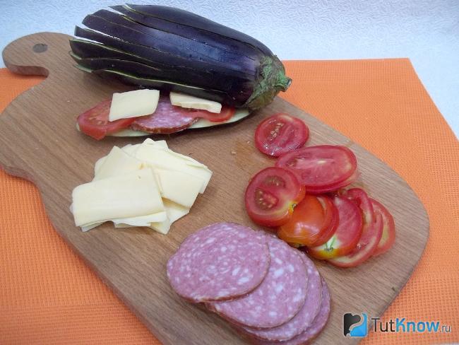 Между разрезаны баклажанов выложены слайсы продуктов