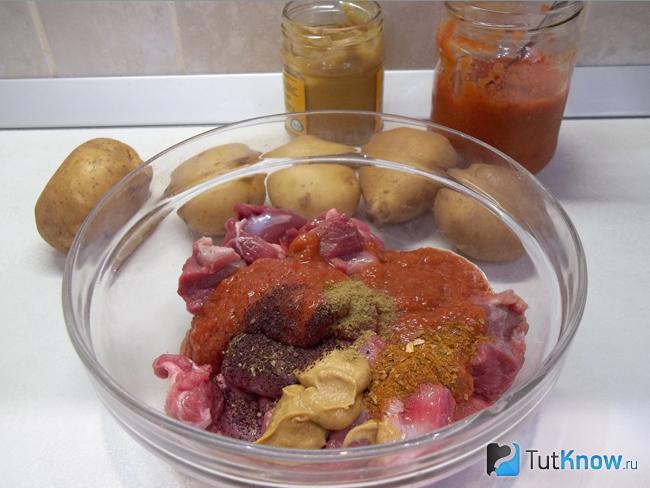 Мясо сложено в миску и замариновано в аджике