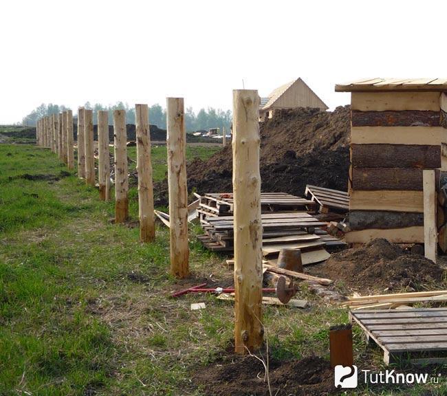 Установка деревянных столбов под забор из горбыля
