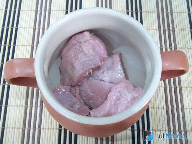 Мясо нарезано и выложено в горшочки