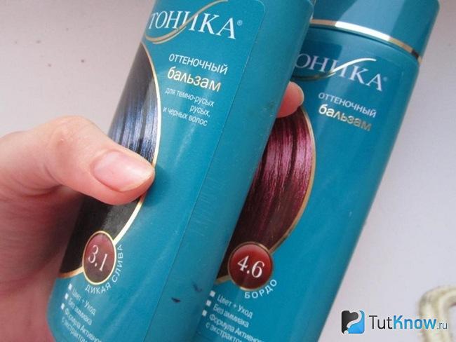 Два флакона с тоником для волос в руке