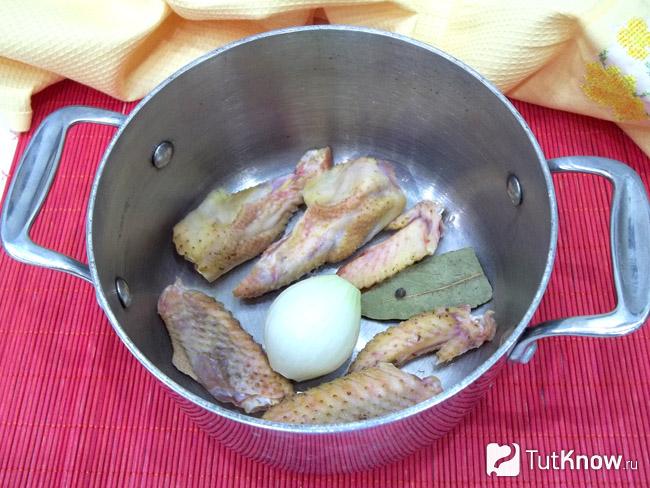 Курица нарезана и сложена в кастрюлю с луком