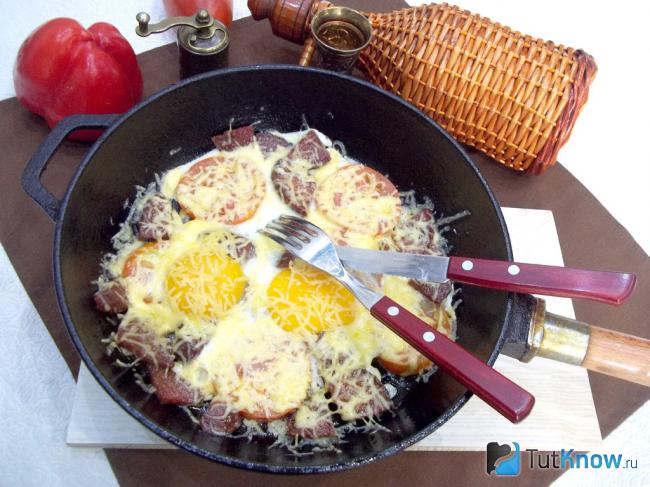 Готовая яичница с помидорами, колбасой и сыром