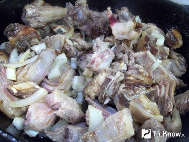 Ребрышки жарятся с луком