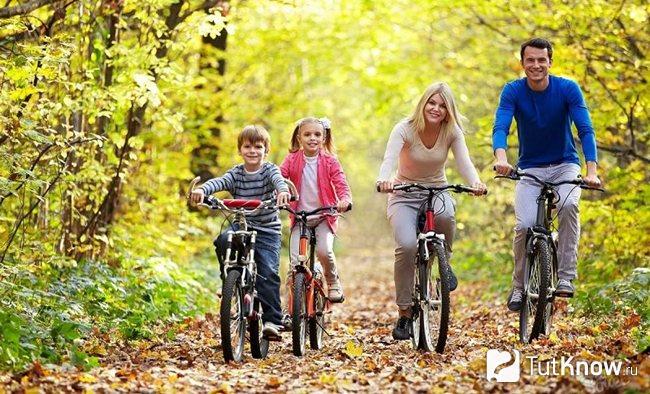 Семья катается на велосипедах по осеннему парку