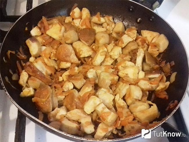 Тушенные курица, лук и морковь в сковороде