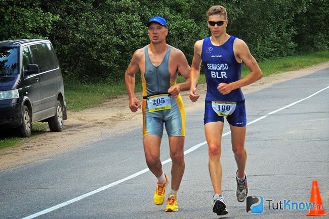 Два триатлониста бегут по дороге