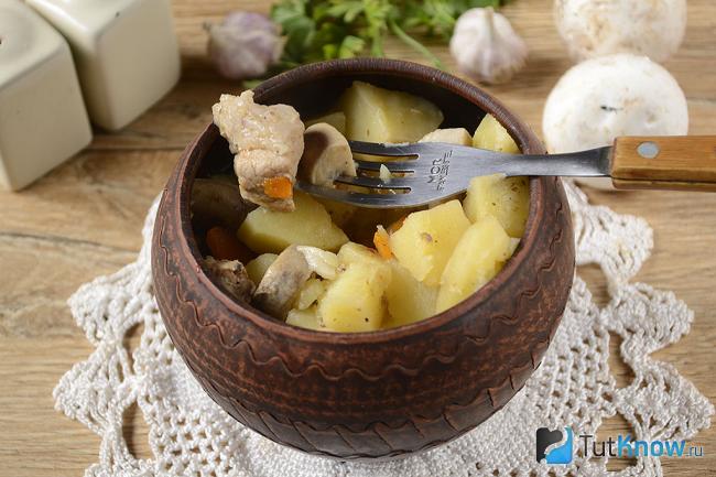 Жаркое с мясом и грибами в горшочке на столе
