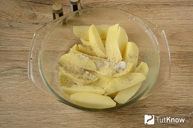 Почищенная и порезанная картошка со специями
