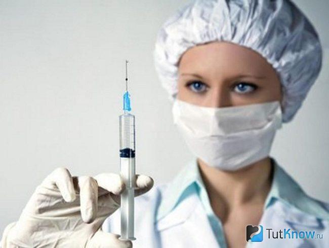 Девушка врач со шприцем в руке