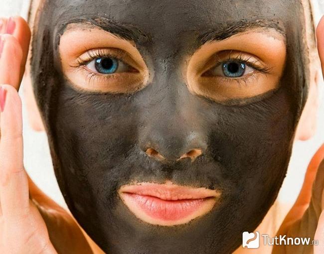 Черная очищающая маска на лице девушки