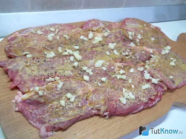 Мясо присыпано чесноком и специями