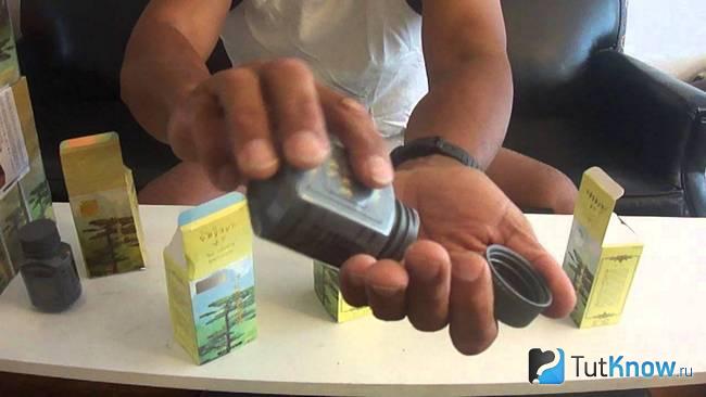 Мужчина высыпает капсулы Ginseng Kianpi Pil себе в руку