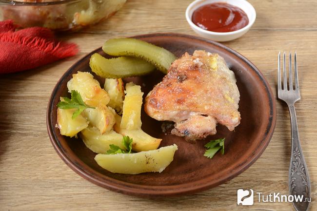 Готовые куриные бёдра с картошкой на тарелке
