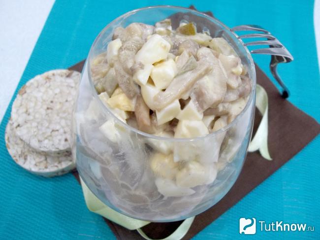 Готовый салат с маринованными грибами, яйцами и солеными огурцами