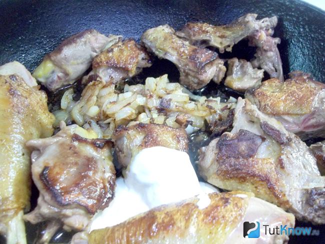 В сковороде соединены курица, лук и сметана